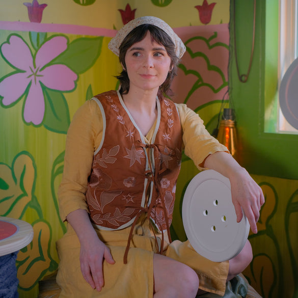 Person in a retro-style room with colorful walls and a window.