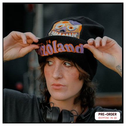 Black, orange, and purple knit beanie in 10% wool, 90% acrylic, featuring a thick rib knit band and embroidered detailing.