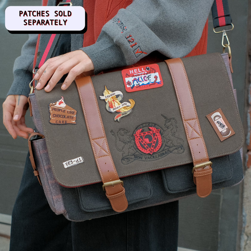Red, grey, and brown canvas Satchel with plaid lining, featuring a padded laptop pocket, adjustable strap, and magnetic closure. 