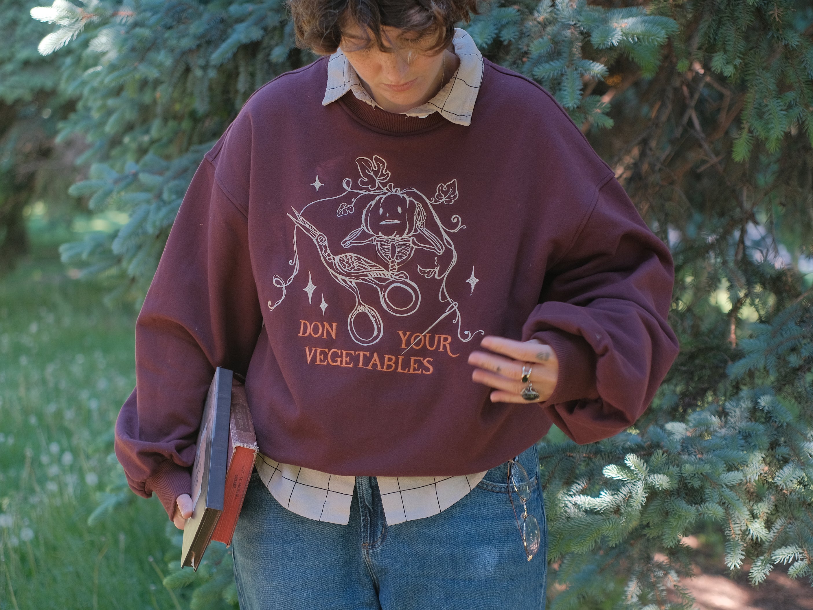 Cozy, oversized, puff-sleeved, cotton with fleece-lining, crewneck sweater in burgundy. The sweater features an intricately embroidered design in white and orange, of a pumpkin skeleton, vines, stork scissors, and reads â€œDon Your Vegetablesâ€.