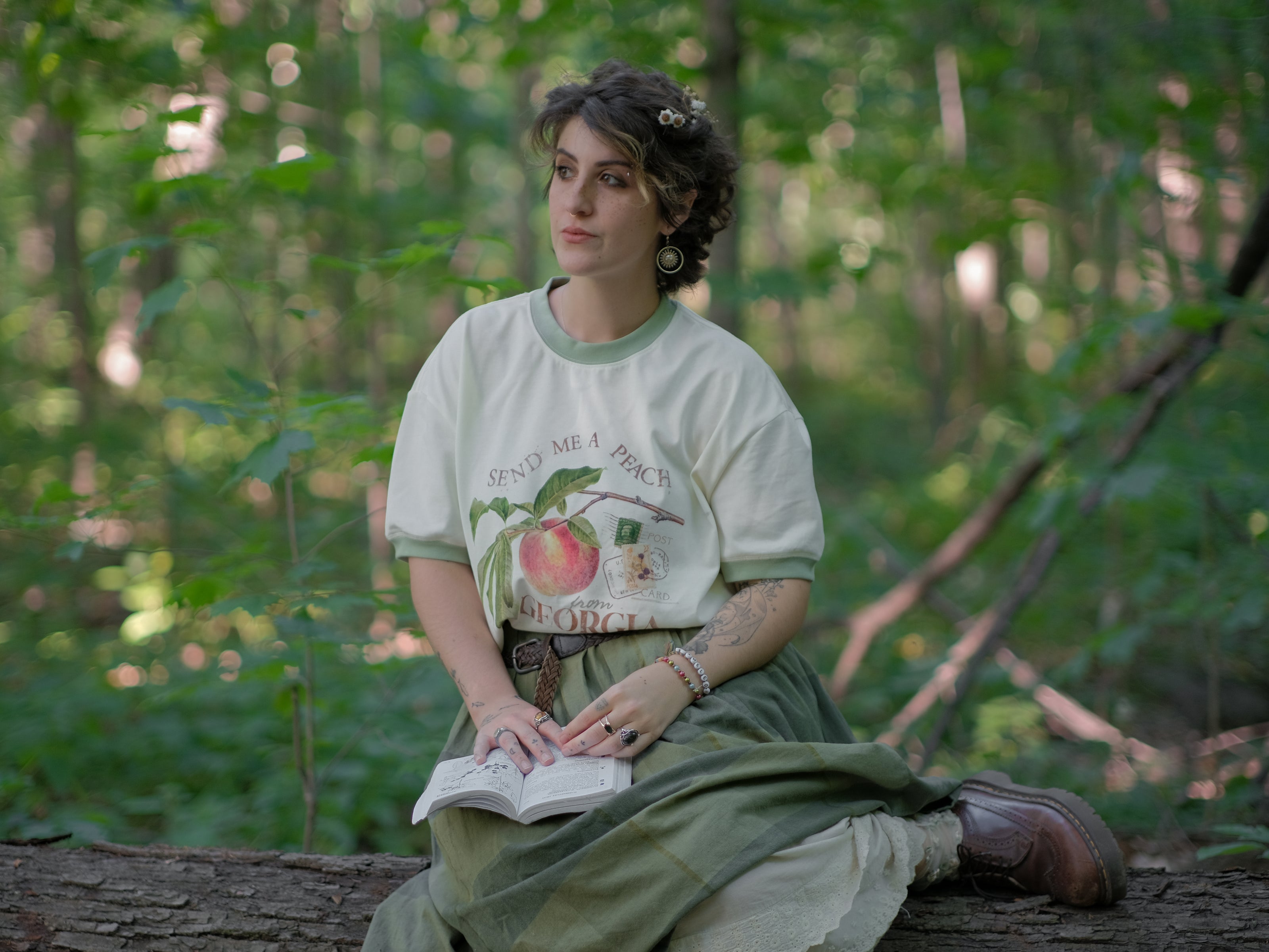A cotton, vintage-style ringer t-shirt, in shades of soft cream and sage. The shirt is printed with a faded vintage peach design with postage stamps, and reads â€œsend me a peach from Georgiaâ€.