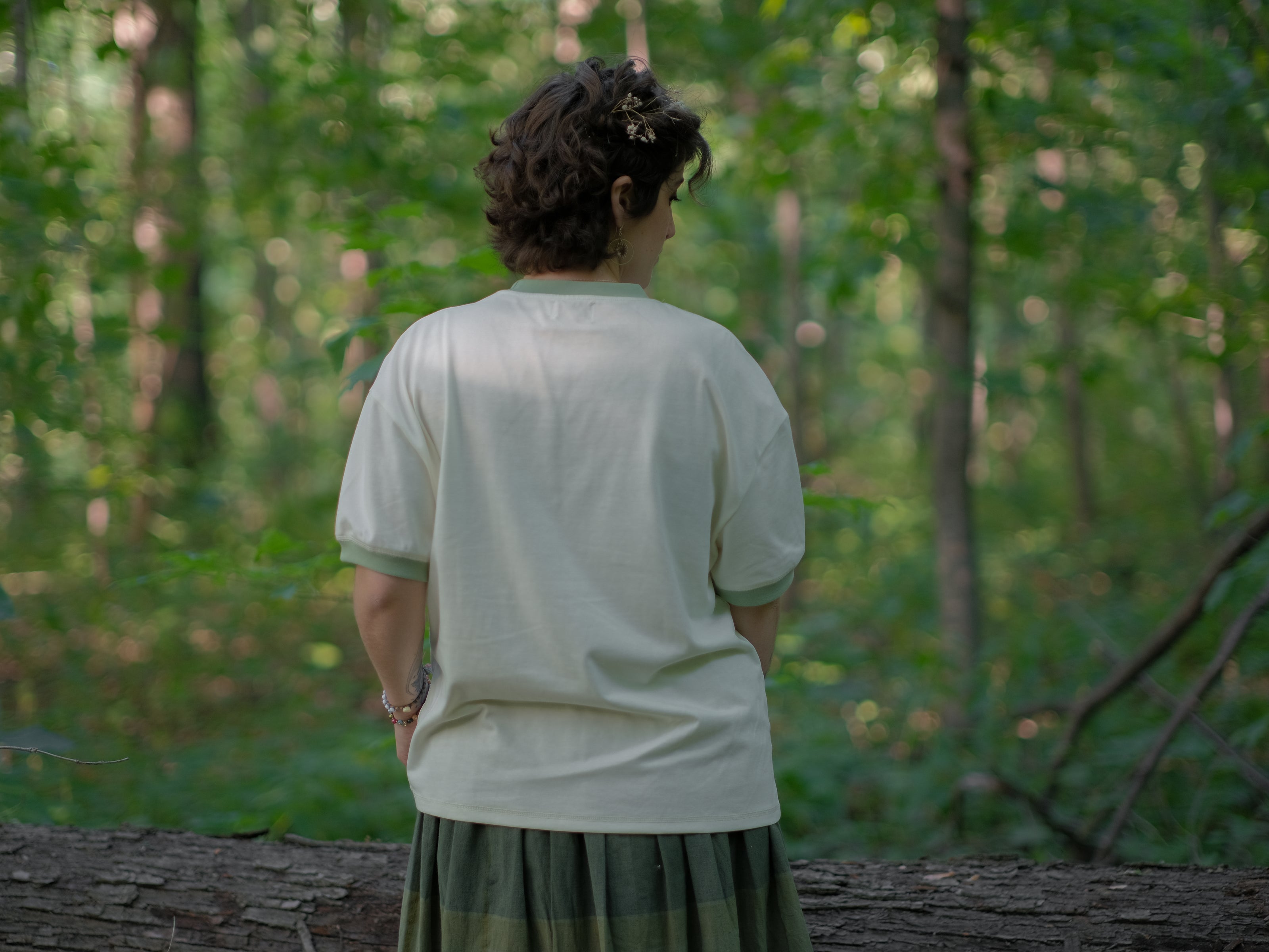 A cotton, vintage-style ringer t-shirt, in shades of soft cream and sage. The shirt is printed with a faded vintage peach design with postage stamps, and reads â€œsend me a peach from Georgiaâ€.