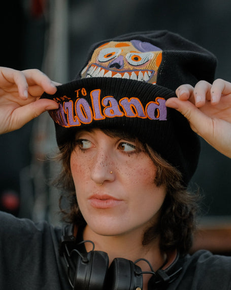 Black, orange, and purple knit beanie in 10% wool, 90% acrylic, featuring a thick rib knit band and embroidered detailing.