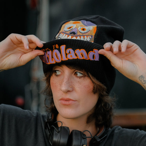Black, orange, and purple knit beanie in 10% wool, 90% acrylic, featuring a thick rib knit band and embroidered detailing.