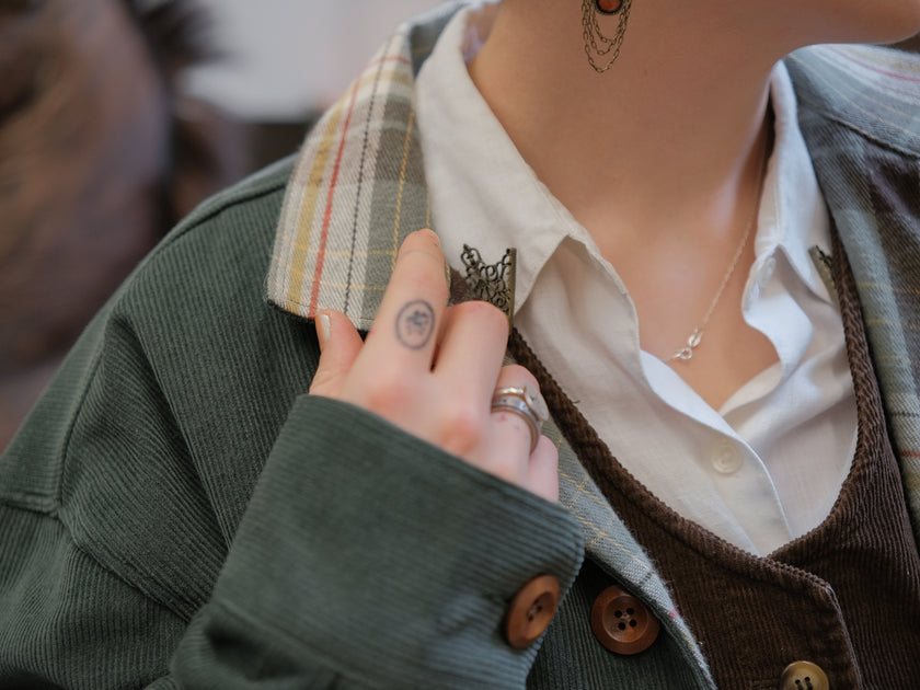 Dark green fall/spring button up corduroy jacket with soft brown plaid lining, featuring embroidered thistles, pollinators, and their Latin names.