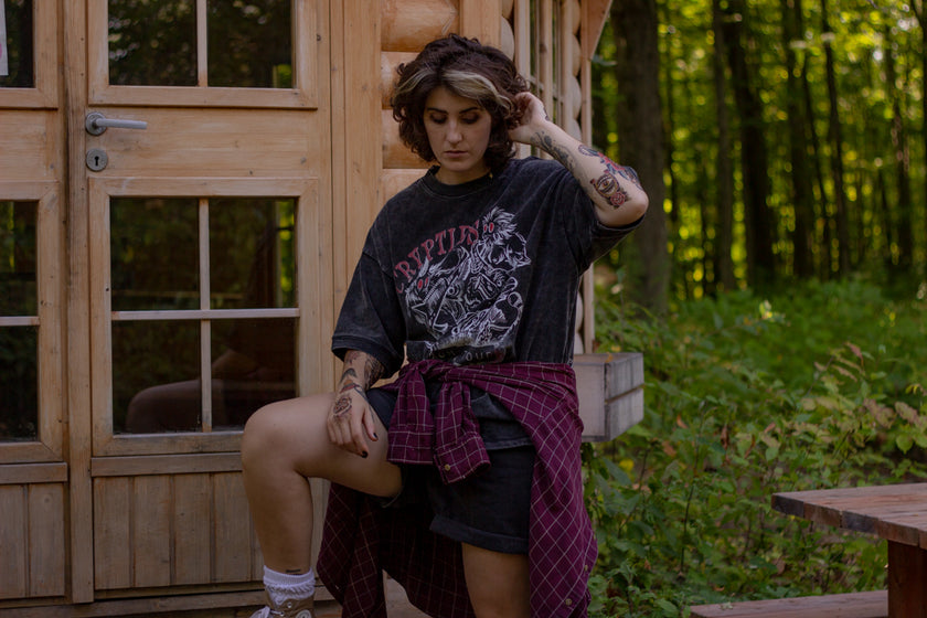 Black acid-washed oversized 80's style cotton band t-shirt with a vintage-style graphic depicting cryptids, including Bigfoot and Mothman, along with the bold text 'Cryptids On Tour' in red and white, and a list of shows across various locations and dates on the back.