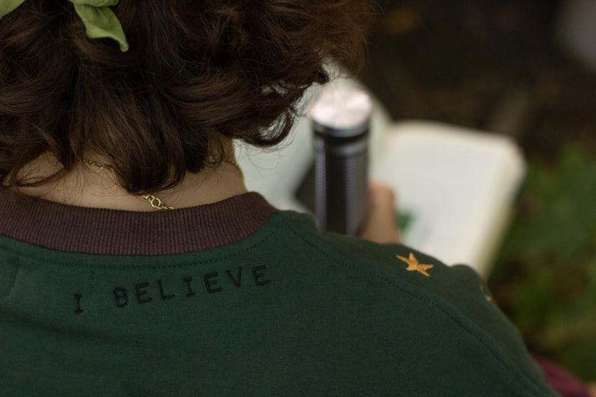 Cozy Forest green, deep yellow, and burgundy cotton crewneck sweatshirt, featuring a vintage, 80â€™s summer camp style embroidered â€œiron onâ€ patches, designed with cryptid-themed symbols and text.