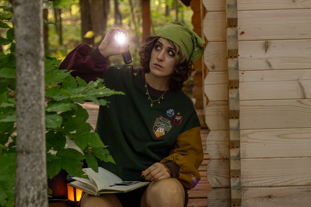 Cozy Forest green, deep yellow, and burgundy cotton crewneck sweatshirt, featuring a vintage, 80â€™s summer camp style embroidered â€œiron onâ€ patches, designed with cryptid-themed symbols and text.