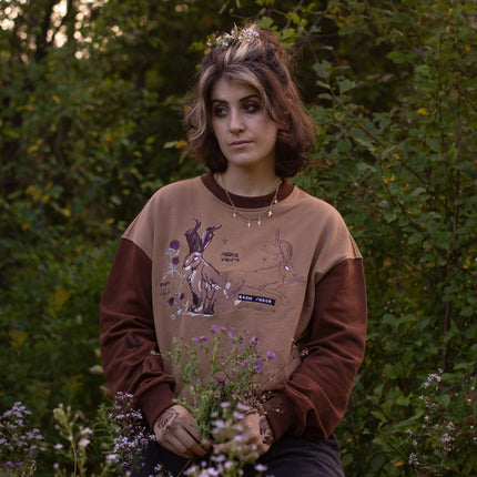 Cozy rust-orange, and peach cotton crewneck sweatshirt, featuring a vintage, embroidered design of the Jackalope with cryptid summer camp-themed symbols and text.