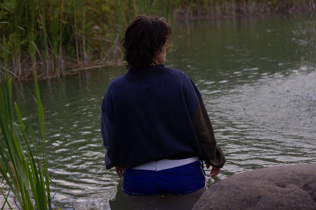 Cozy navy and fog-blue cotton crewneck sweatshirt, featuring a vintage, 80â€™s summer camp style embroidered design of the Mothman with cryptid-themed symbols and text.