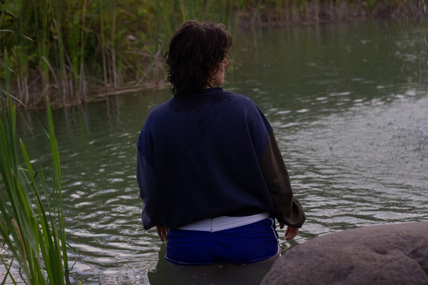 Cozy navy and fog-blue cotton crewneck sweatshirt, featuring a vintage, 80â€™s summer camp style embroidered design of the Mothman with cryptid-themed symbols and text.