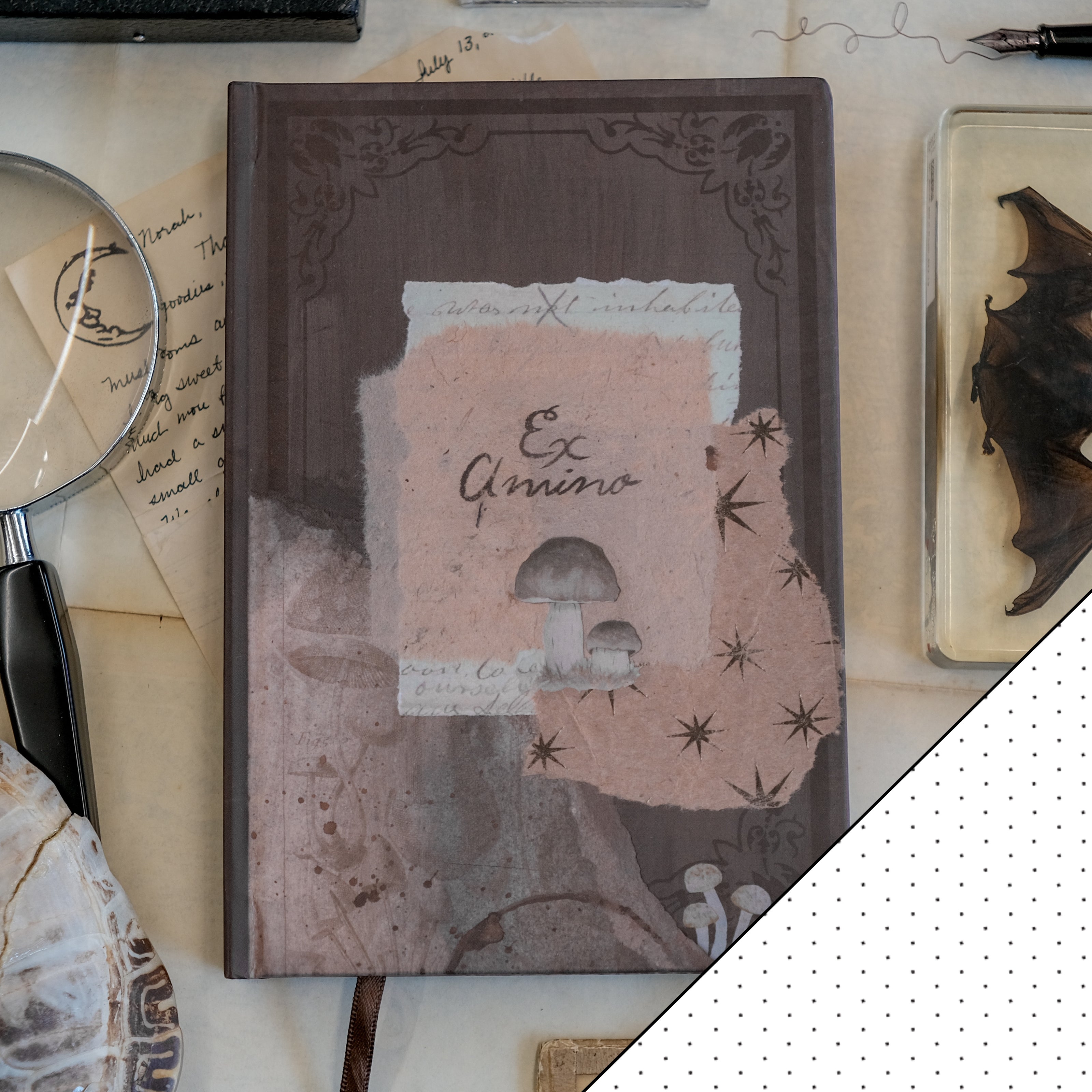 A dark mauve notebook with copper gilded edges, a satin reading ribbon and vintage design, titled 