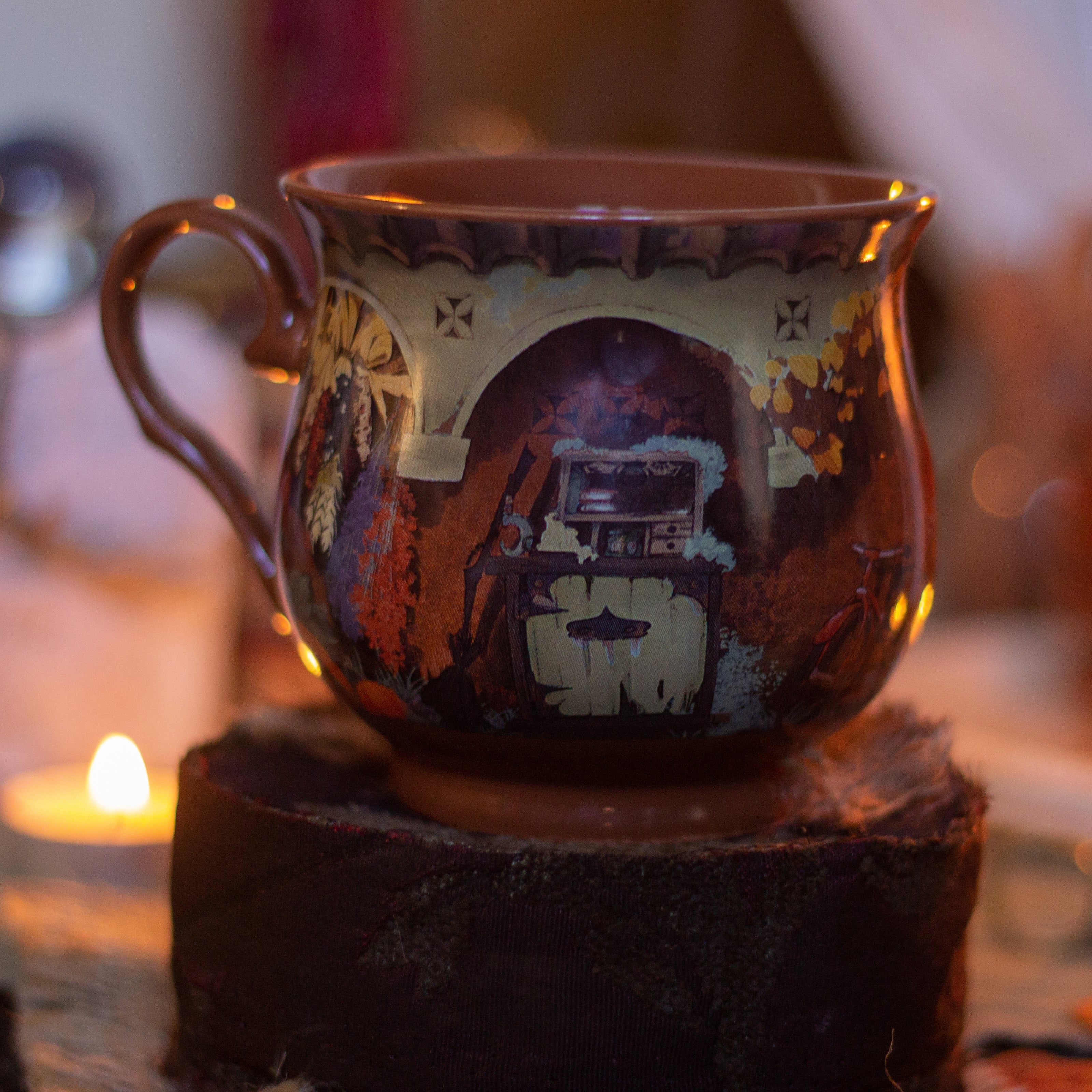 Persimmon orange heat-sealed 360Â° printed mug of a witchâ€™s cottage,  featuring a warm autumnal design with a sleeping kitten, pumpkins, leaves, and a vintage arched doorway scene, placed on a cozy table. Harvest drying out for winter and much more. Microwave and dishwasher safe. They are a rounded shape with a wide lip, to keep your hands cozy all winter long. 