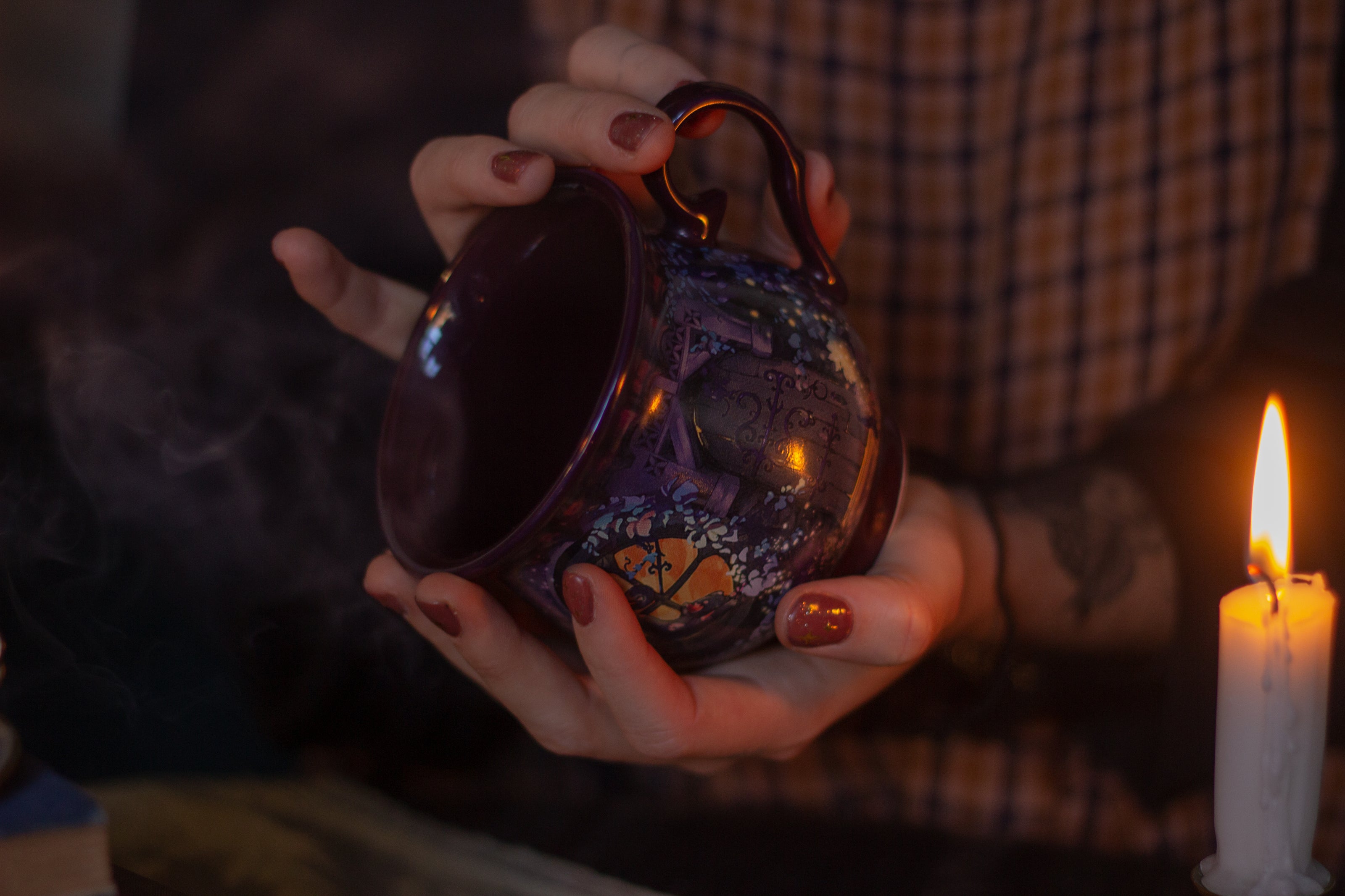 Two intricately designed witches cottage ceramic mugs, featuring vibrant seasonal and whimsical artwork. The top mug showcases an autumnal theme with pumpkins and fall foliage, while the bottom mug highlights an autumnal evening scene with a full moon, a prowling cat, and dark, enchanting colors.