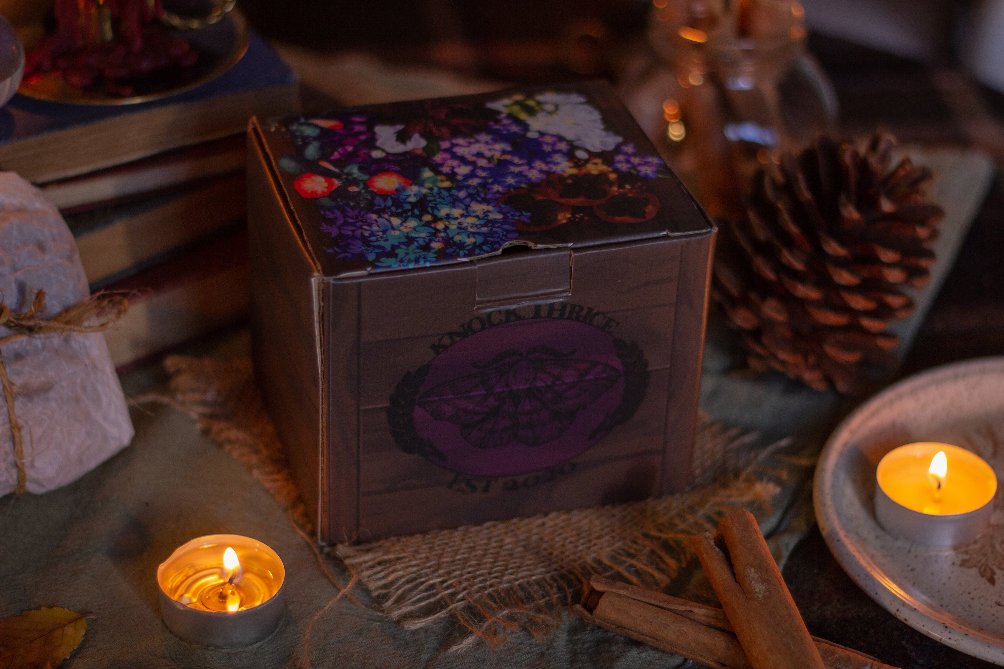 Two intricately designed witches cottage ceramic mugs, featuring vibrant seasonal and whimsical artwork. The top mug showcases an autumnal theme with pumpkins and fall foliage, while the bottom mug highlights an autumnal evening scene with a full moon, a prowling cat, and dark, enchanting colors.