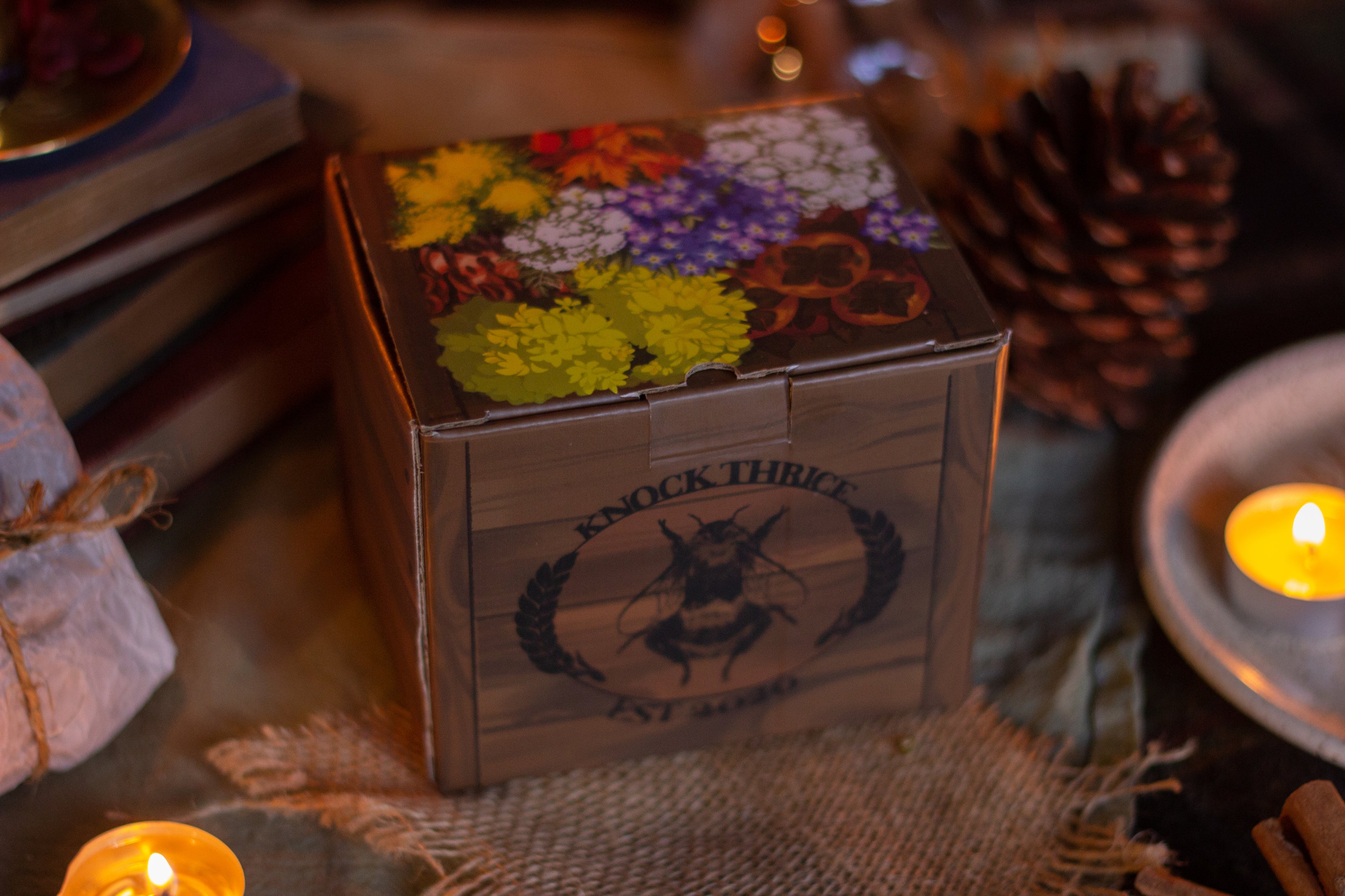 Two intricately designed witches cottage ceramic mugs, featuring vibrant seasonal and whimsical artwork. The top mug showcases an autumnal theme with pumpkins and fall foliage, while the bottom mug highlights an autumnal evening scene with a full moon, a prowling cat, and dark, enchanting colors.