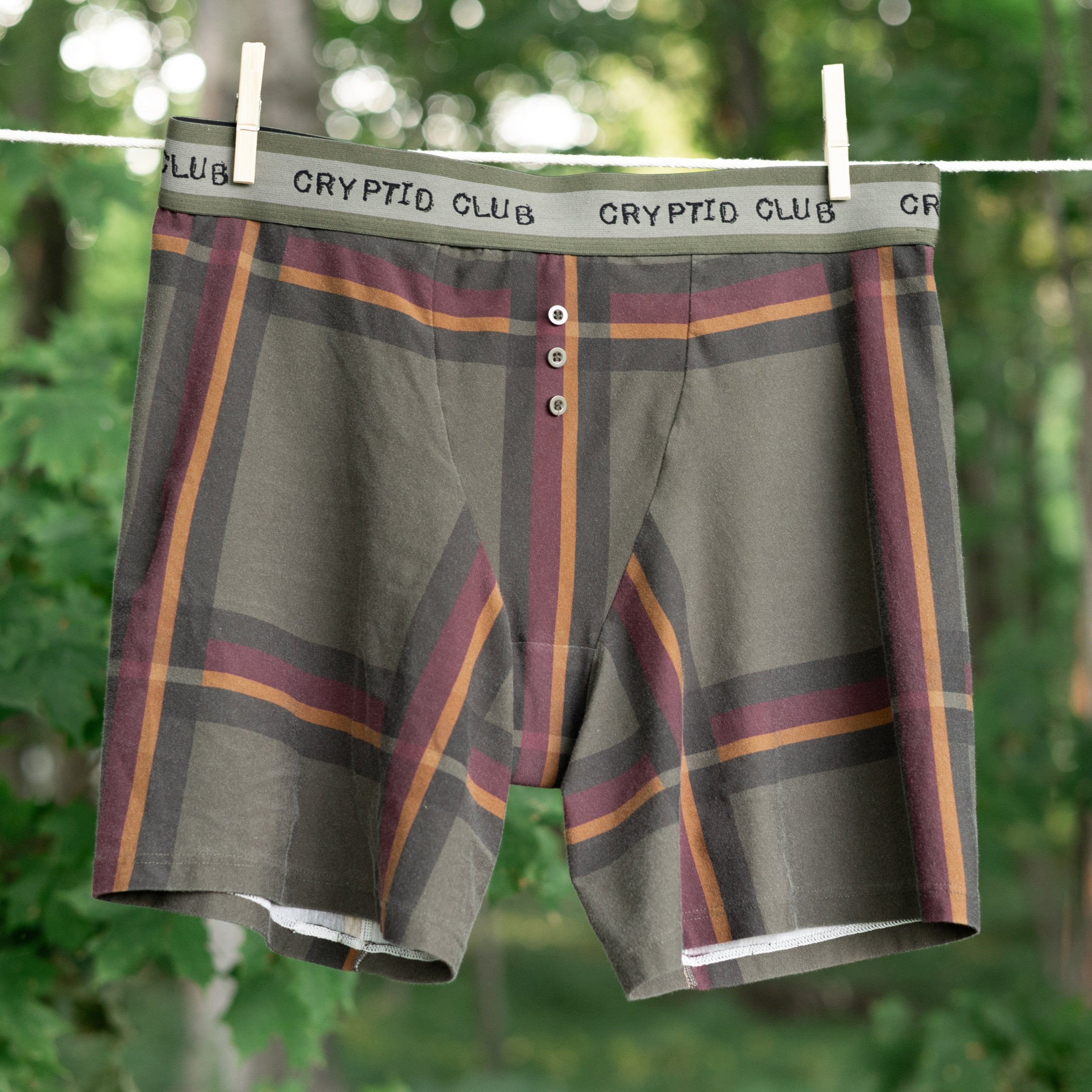 Knock Thrice Knoxers // burgundy, olive green, and mustard yellow plaid, cotton, fitted boxers. The boxers are mid-high rise,  and have a green and grey spandex waistband that reads 