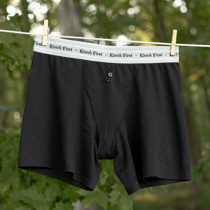 Knock Thrice Knoxers // black cotton, fitted, unisex boxer briefs. The boxers are mid-high rise,  and have a grey spandex waistband that reads 