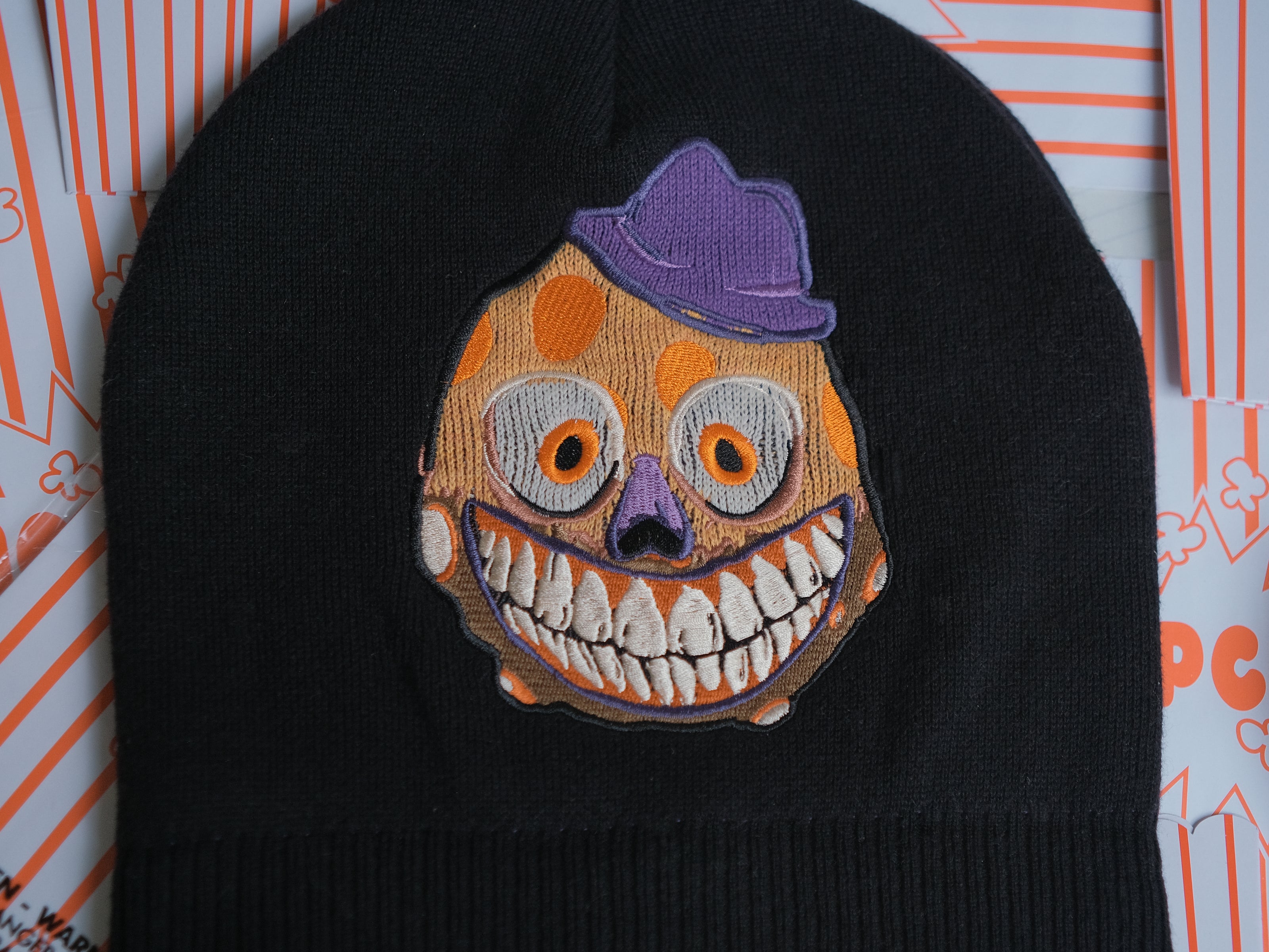Knock Thrice x Rusty Quill â€œWelcome to Bonzoland!â€ black Knit Beanie from The Magnus Protocol. The beanie features Mr. Bonzoâ€™s happy face and hidden horrors beneath the brim. Ribbed band with â€˜Welcome to Bonzolandâ€™ embroidery.