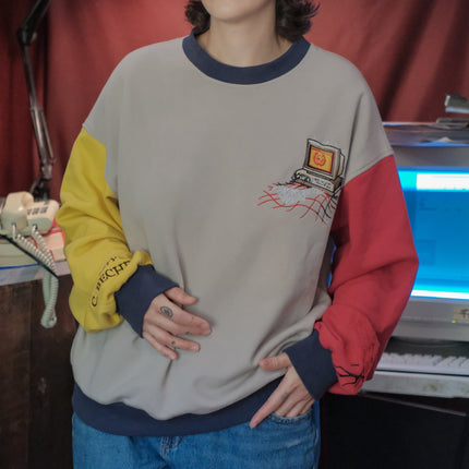 Magnus Protocol, I.T department, cotton jersey crewneck, in beige, with red and yellow colour blocked sleeves. The sweater features vaporwave computer embroidered details, and reads â€œProperty of C. Becherâ€.