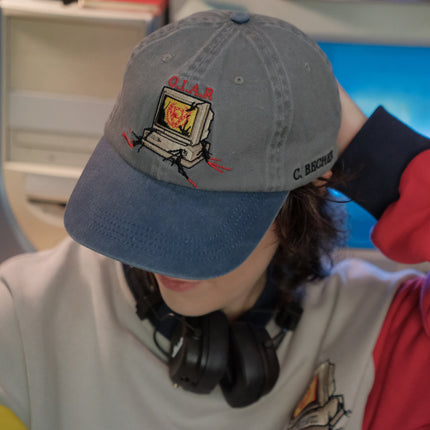 Knock Thrice x Rusty Quill, 100% cotton I.T Department Dad Cap in blue and grey. The hat features an embroidered design of a corrupted computer and glitched OIAR logo, and an adjustable fit.