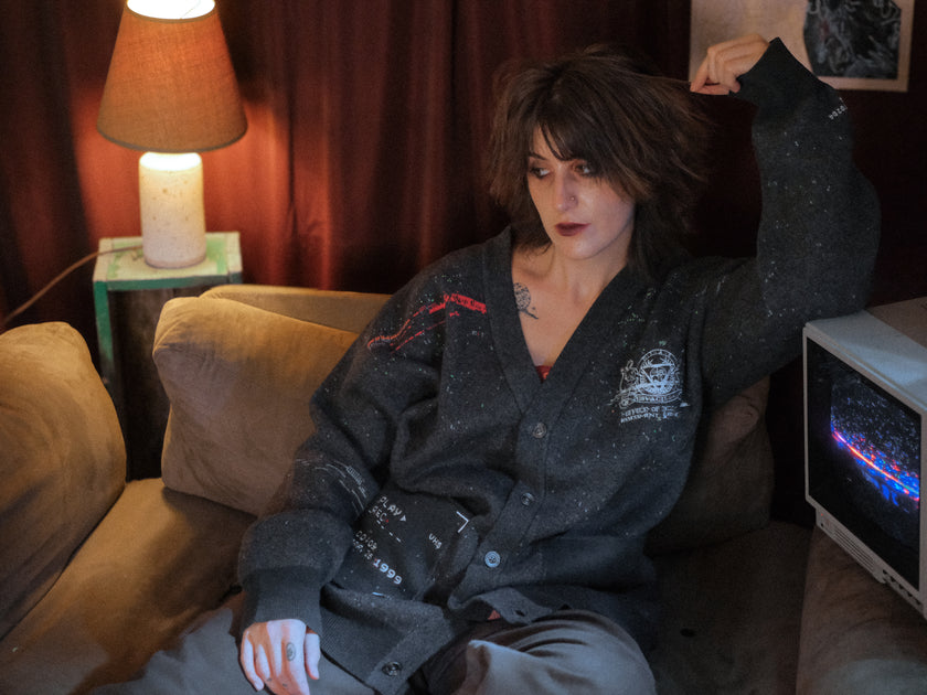 Magnus Protocol, oversized, knit-cardigan, in black. The cardigan is inspired by old cassette tapes, and features embroidered analog details, and the OIAR crest.