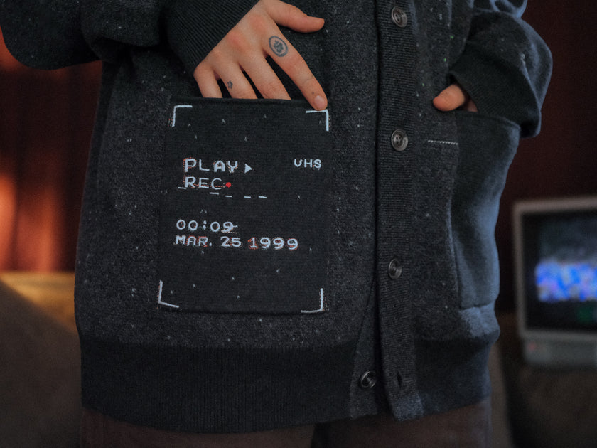 Magnus Protocol, oversized, knit-cardigan, in black. The cardigan is inspired by old cassette tapes, and features embroidered analog details, and the OIAR crest.