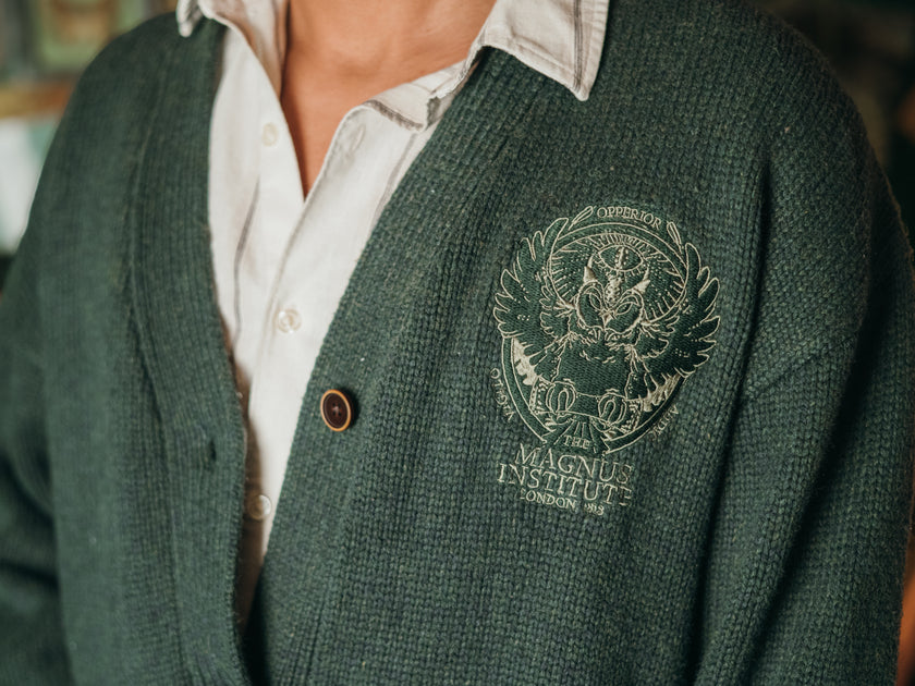 Magnus Archives x Knock Thrice oversized knit cardigan with embroidered details in dark green. Made of 60% Cotton 30% Nylon 10% Wool.