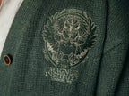 Magnus Archives x Knock Thrice oversized knit cardigan with embroidered details in dark green. Made of 60% Cotton 30% Nylon 10% Wool.