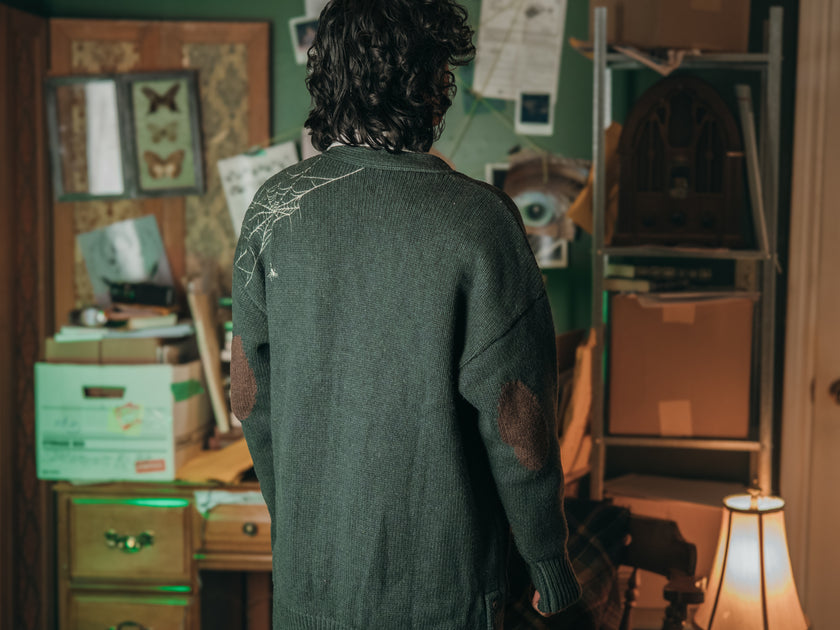 Magnus Archives x Knock Thrice oversized knit cardigan with embroidered details in dark green. Made of 60% Cotton 30% Nylon 10% Wool.