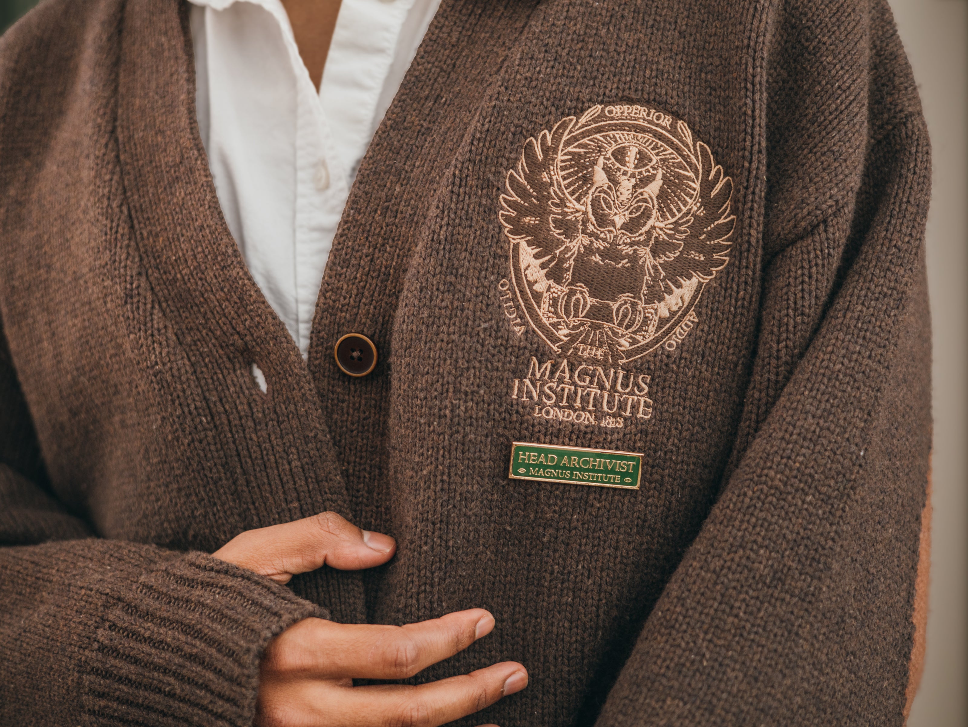 Magnus Archives x Knock Thrice green and gold enamel lapel pin with eye details.