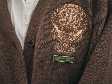 Magnus Archives x Knock Thrice green and gold enamel lapel pin with eye details.