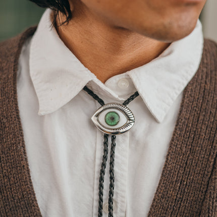 Magnus Archives x Knock Thrice adjustable, leather green-eye bolo tie, with silver details.