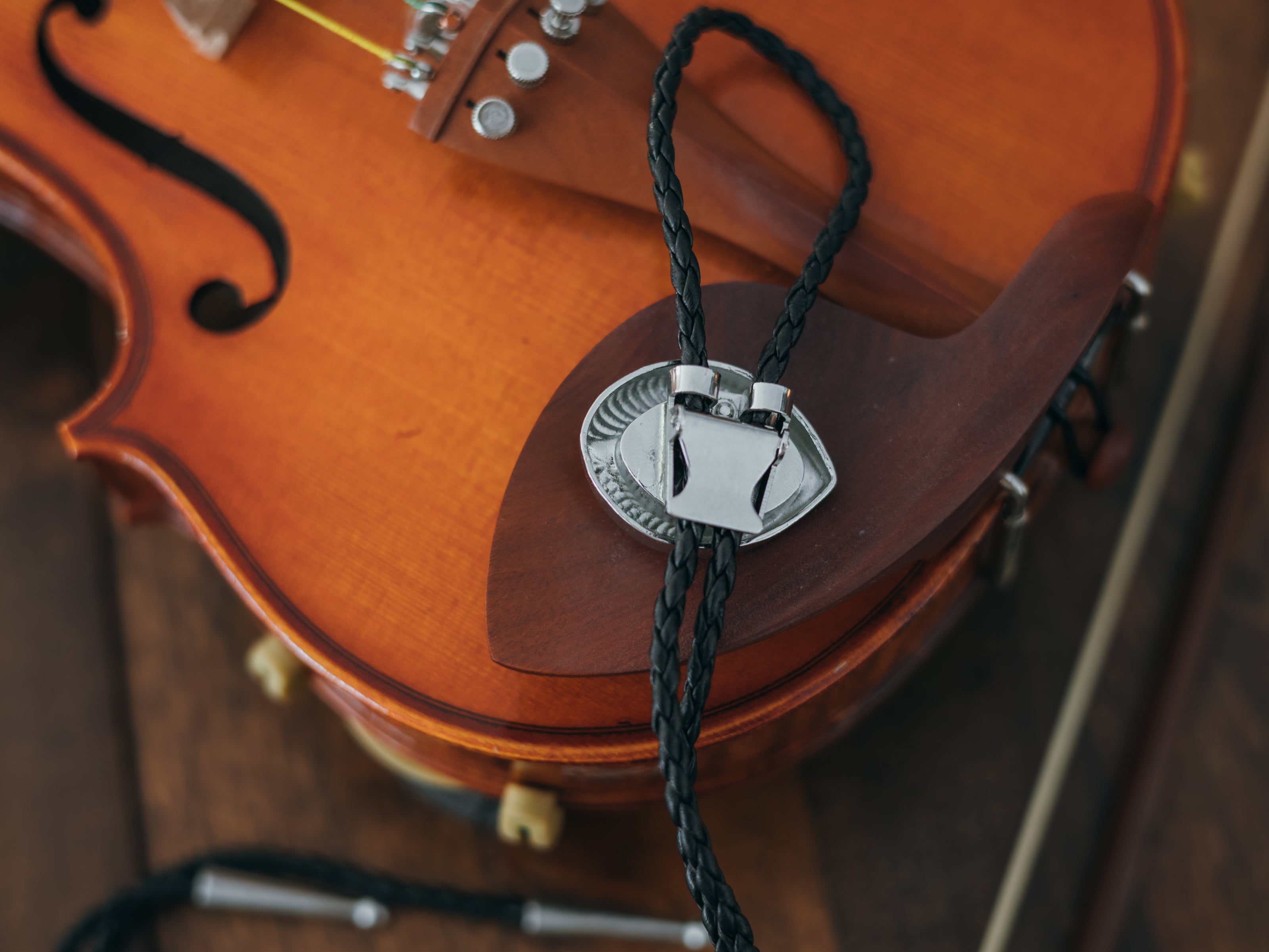 Magnus Archives x Knock Thrice adjustable, leather green-eye bolo tie, with silver details.