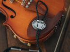 Magnus Archives x Knock Thrice adjustable, leather green-eye bolo tie, with silver details.