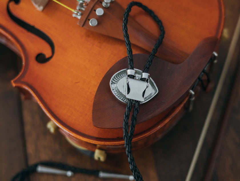 Magnus Archives x Knock Thrice adjustable, leather green-eye bolo tie, with silver details.