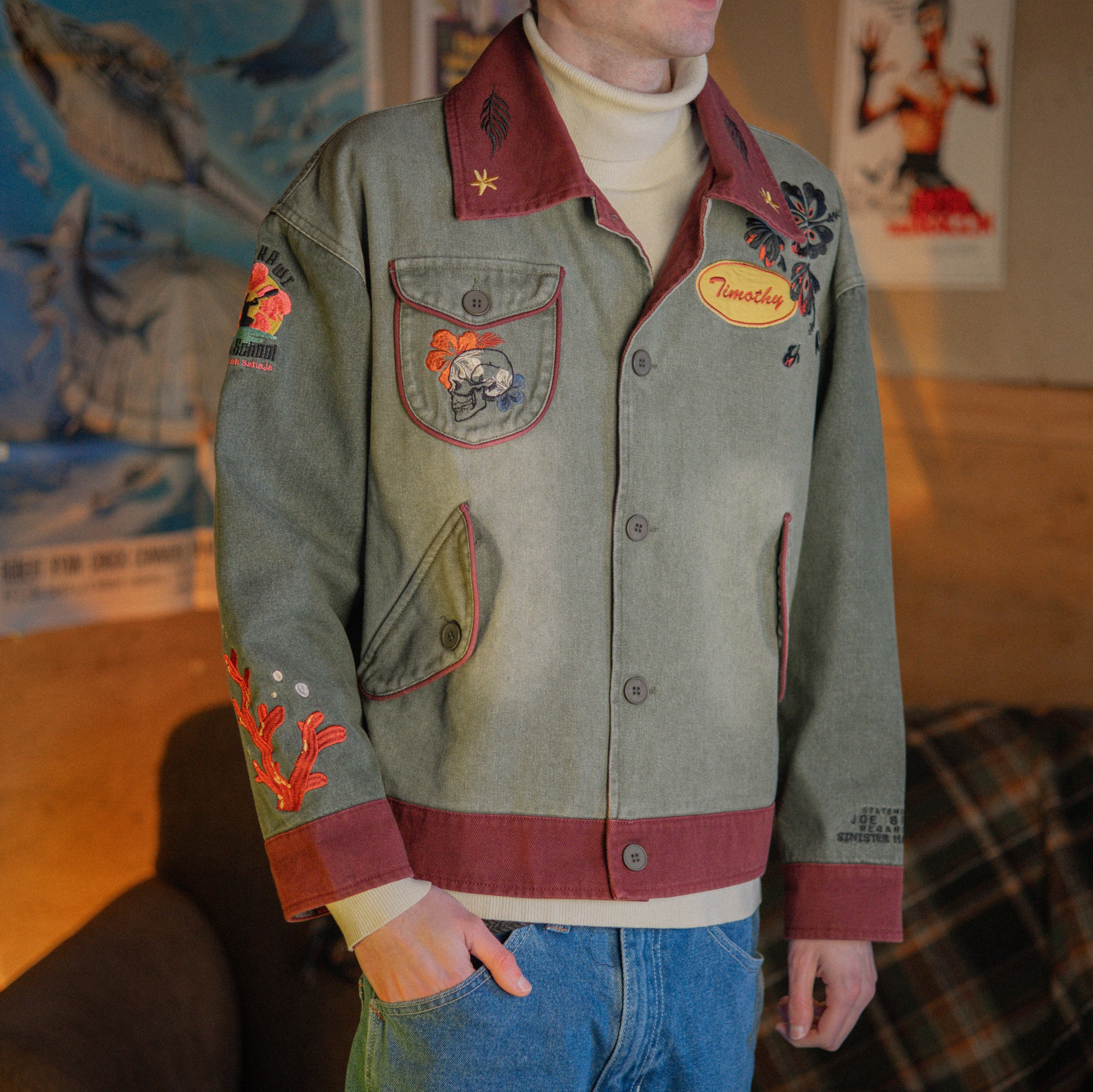 Knock Thrice x Rusty Quill, black fall/spring button-up cotton jacket. The jacket features both embroidered and patchwork OIAR themed elements, in red, and green.