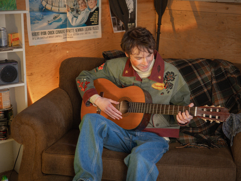Knock Thrice x Rusty Quill, black fall/spring button-up cotton jacket. The jacket features both embroidered and patchwork OIAR themed elements, in red, and green.