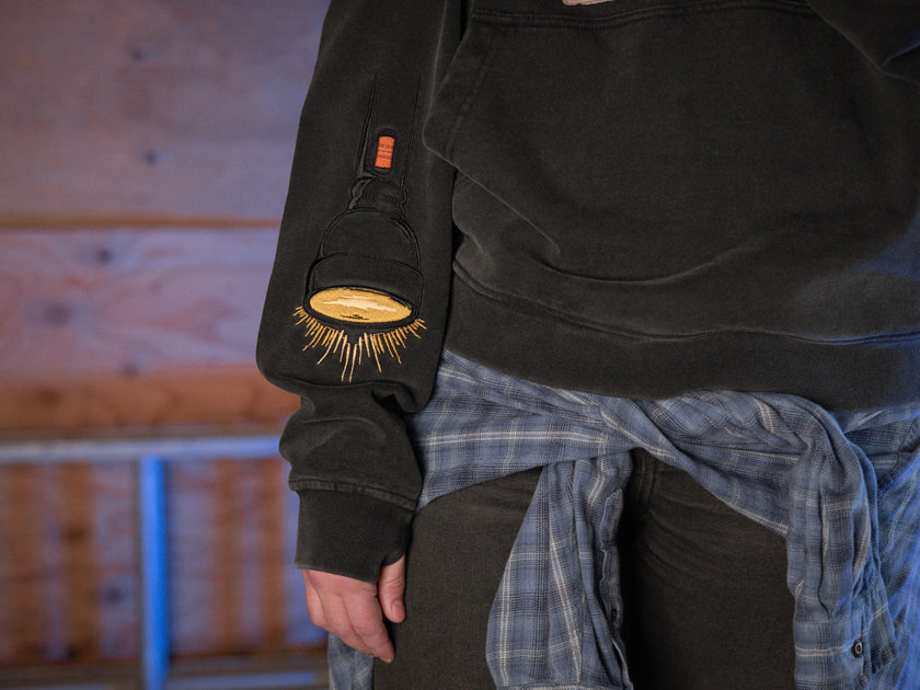 Rusty Quill X Knock Thrice 100% cotton hoodie in black, with a boxy, oversized, slightly cropped fit. The hoodie features both printed and embroidered details.