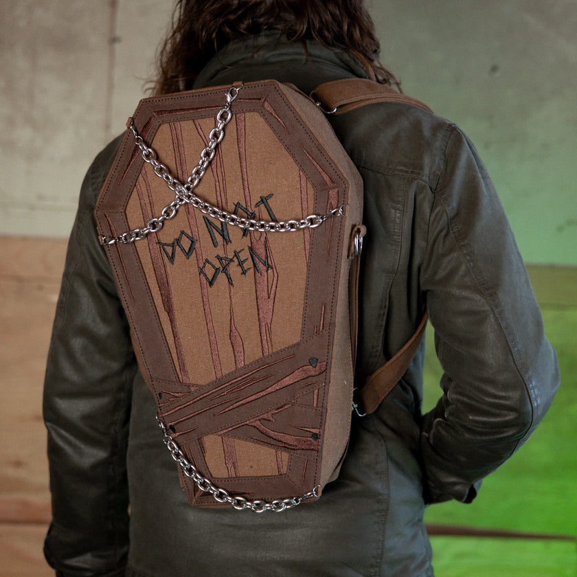 Knock Thrice X Rusty Quill 100% cotton canvas bag with customizable straps allow this bag to be worn as a purse, cross body or backpack. Real metal chains attach to exterior metal rings. Interior is 100% polyester print lining for easy cleaning. 
The bag is 29cm wide, 45cm long and 10cm deep. 