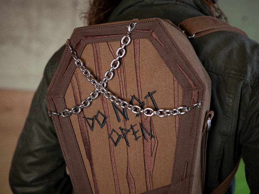 Knock Thrice X Rusty Quill 100% cotton canvas bag with customizable straps allow this bag to be worn as a purse, cross body or backpack. Real metal chains attach to exterior metal rings. Interior is 100% polyester print lining for easy cleaning. 
The bag is 29cm wide, 45cm long and 10cm deep. 