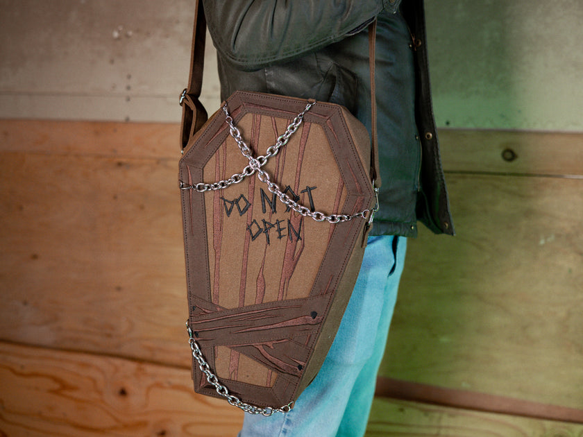 Knock Thrice X Rusty Quill 100% cotton canvas bag with customizable straps allow this bag to be worn as a purse, cross body or backpack. Real metal chains attach to exterior metal rings. Interior is 100% polyester print lining for easy cleaning. 
The bag is 29cm wide, 45cm long and 10cm deep. 