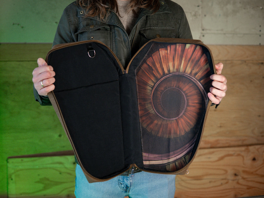 Knock Thrice X Rusty Quill 100% cotton canvas bag with customizable straps allow this bag to be worn as a purse, cross body or backpack. Real metal chains attach to exterior metal rings. Interior is 100% polyester print lining for easy cleaning. 
The bag is 29cm wide, 45cm long and 10cm deep. 