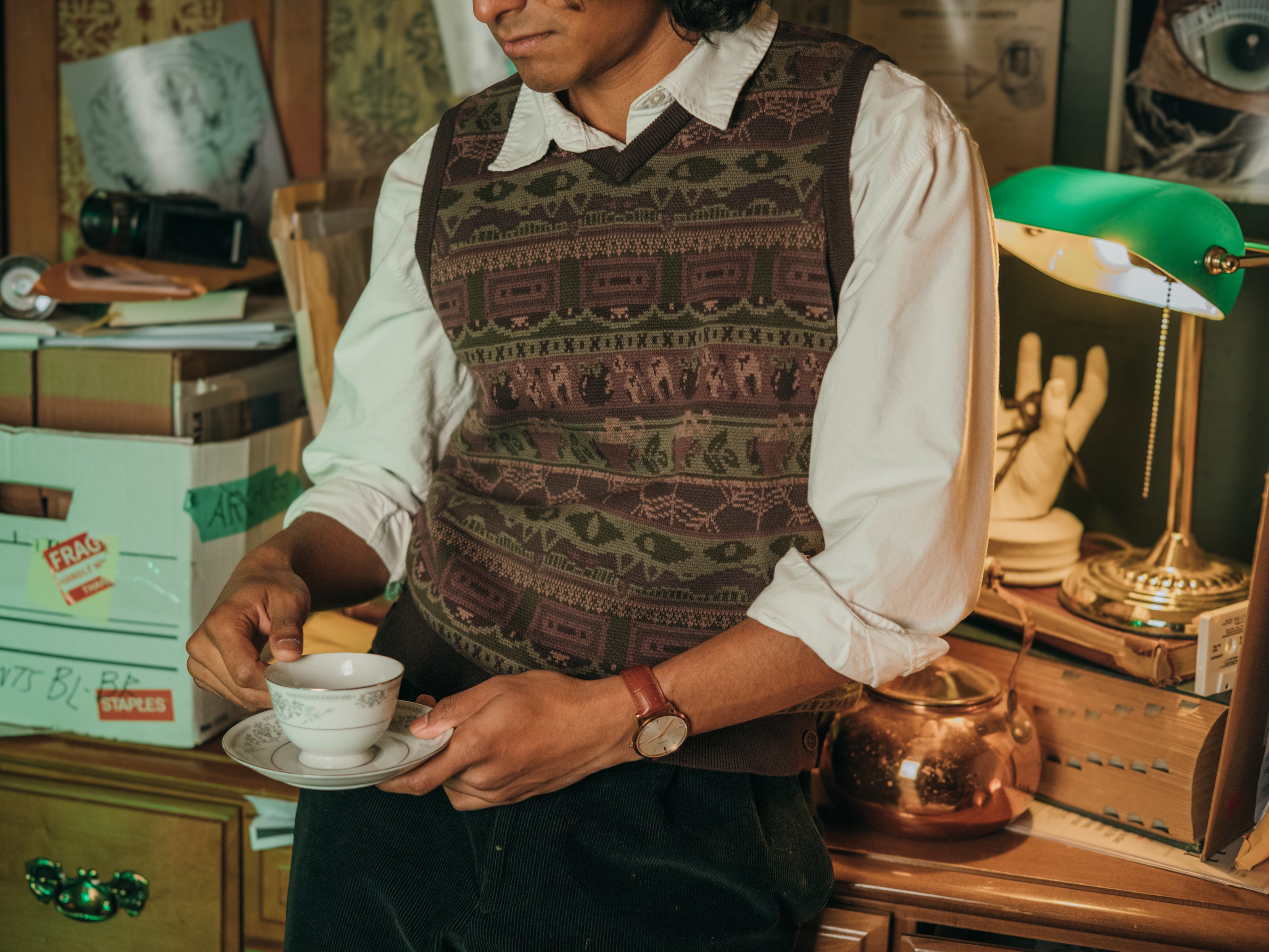 Magnus Archives x Knock Thrice knitted v-neck vest in dark green brown, and burgundy, made of 100% cotton.