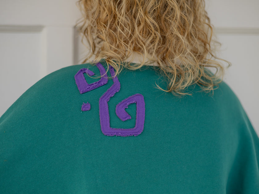 Magnus Archives x Knock Thrice “I’m Not a Who” 100% cotton, graphic crewneck in green and purple, with embroidered details.