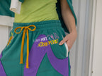 Magnus Archives x Knock Thrice “I’m a What” long shorts in green and purple, 100% cotton graphic shorts with embroidered details